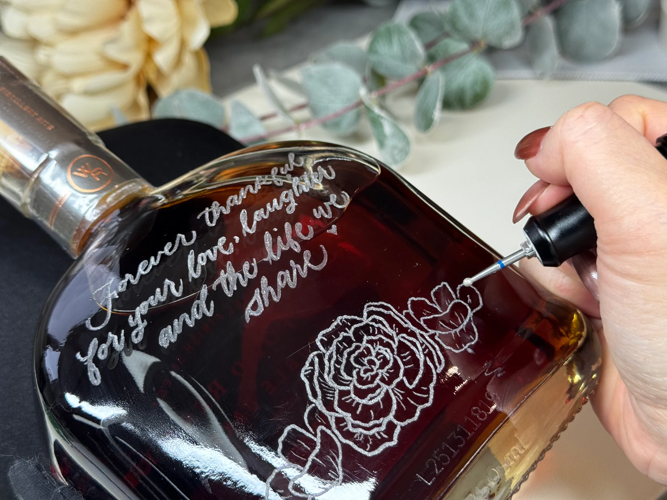 Close-up of hand engraving on a glass bottle