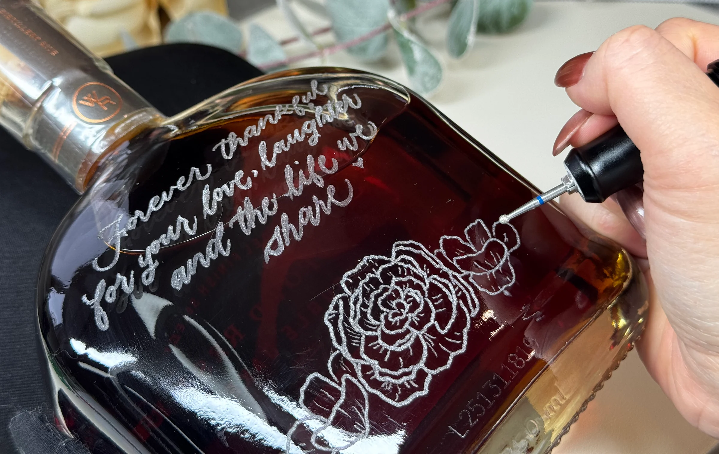 Hand engraving a decorative message on a bottle
