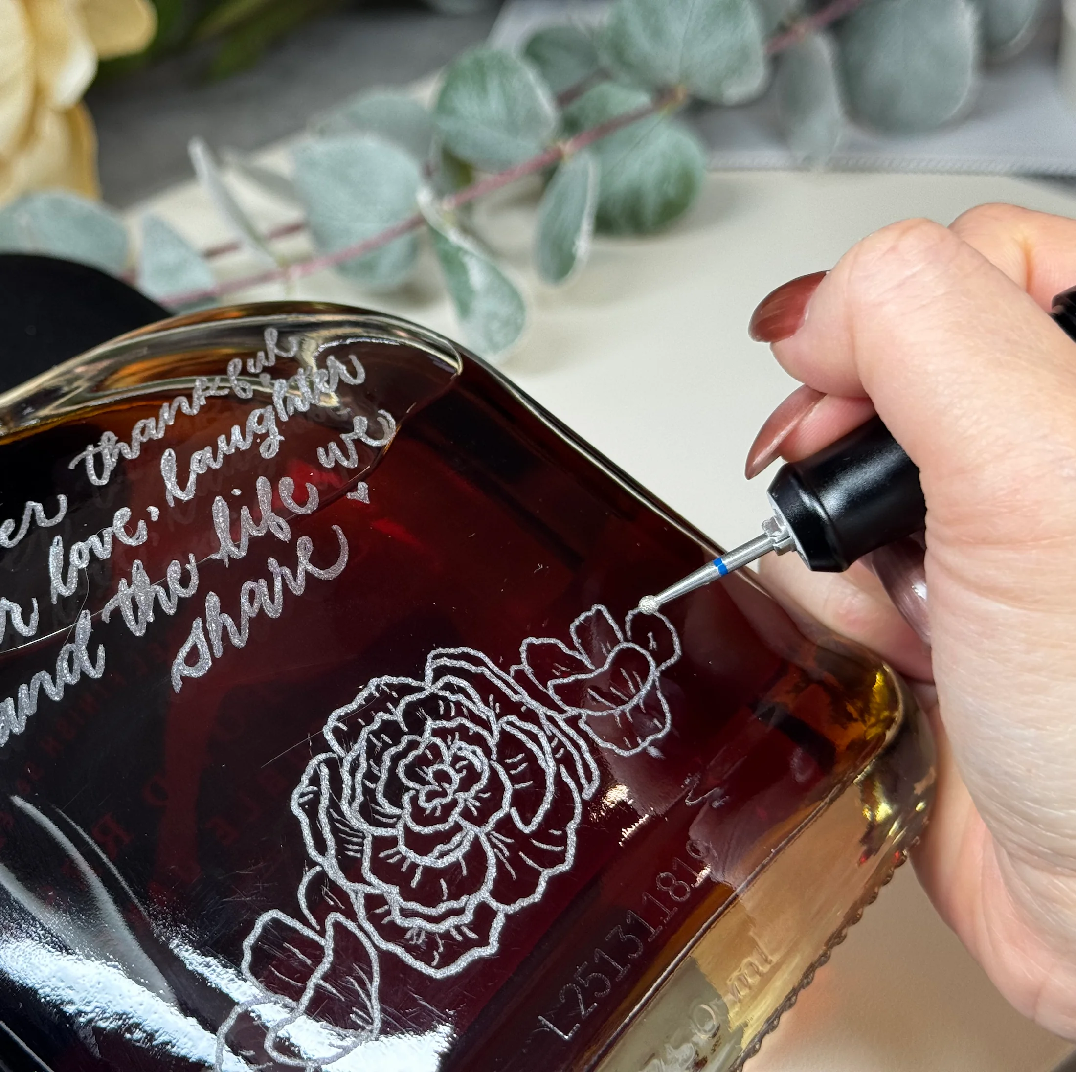 Hand engraving detail on a glass bottle